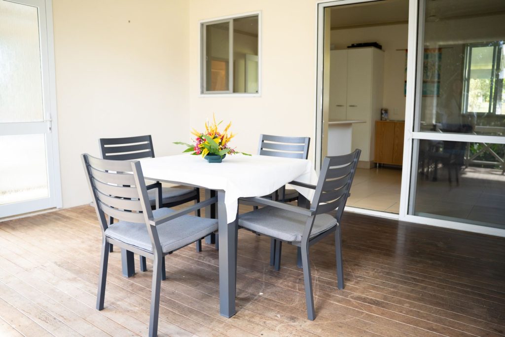 Deck dining table for four beside the sliding doors